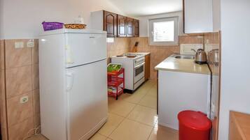 A kitchen with a refrigerator, stove, and sink.