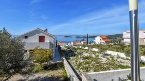 Ein Küstenwohngebiet mit Häusern, wolkenlosem Himmel und Blick auf das Meer.