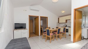 Ein kompakter Wohnbereich mit Essplatz, Küchenzeile und Fernseher im Wohnzimmer.