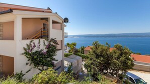 Ein zweistöckiges Gebäude mit einem Balkon, der Blick auf die Küste freigibt.