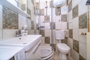 A modern bathroom with a glass-enclosed shower, a white sink, and a toilet. - Apartment Zoran (Postira)