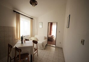A room with a dining table, chairs, a sofa, and a bed. - Apartments Ivan Z (Starigrad)