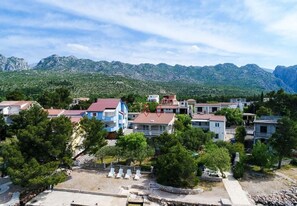 Un pueblo costero con arquitectura tradicional, que incluye casas escalonadas y una zona de playa con tumbonas.