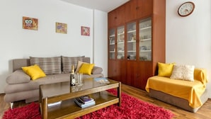 A living room with a sofa, a coffee table, a cabinet, and a clock on the wall. - Apartment Deni (Split)