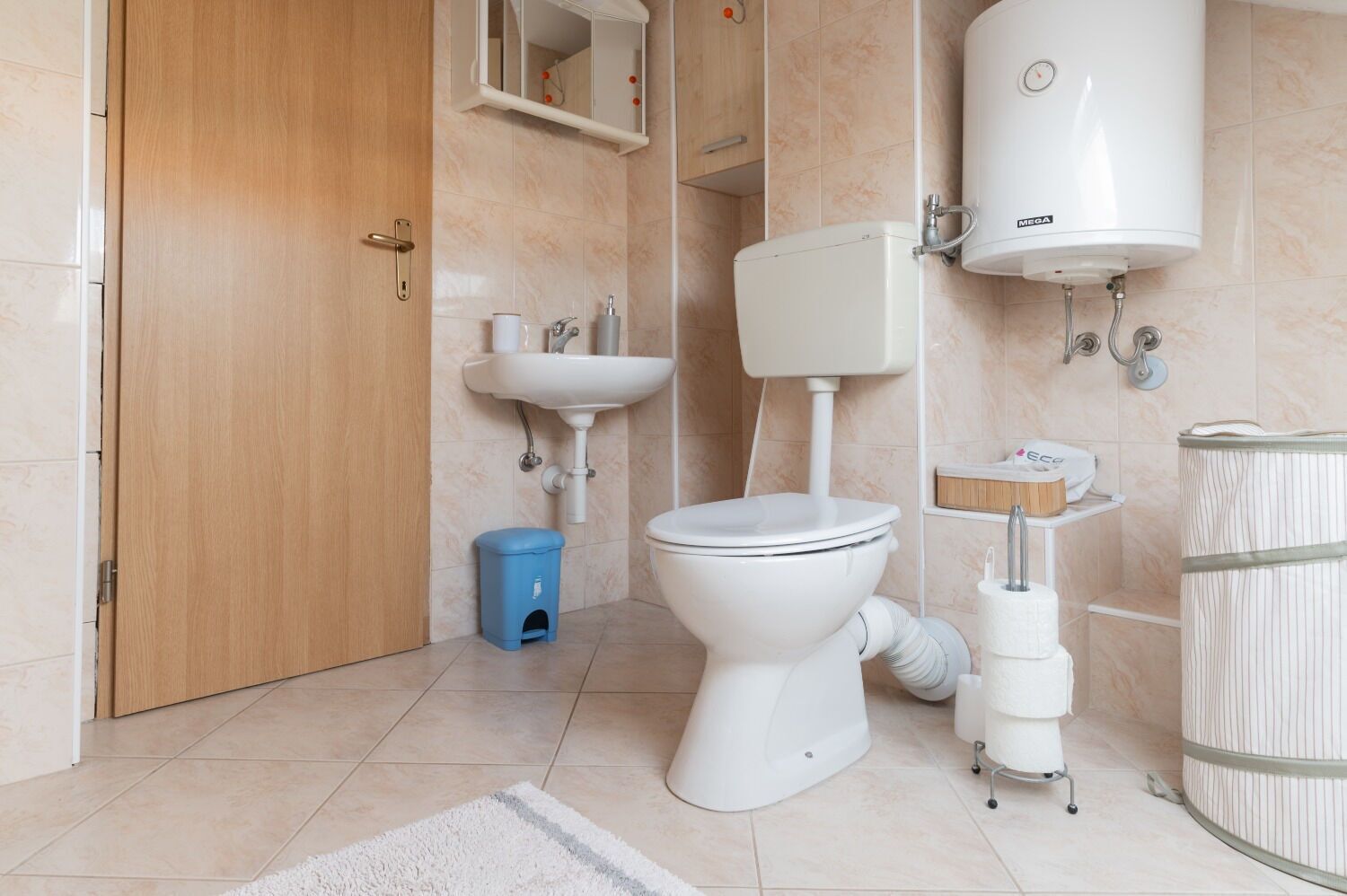 Un baño moderno con inodoro, lavamanos y calentador de agua.