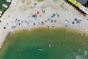 An aerial view of a beach with people, umbrellas, and boats. - Apartments Martina (Sukosan)