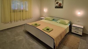 Ein Schlafzimmer mit einem Bett, Nachttischen, einem Teppich und einem Bild an der Wand.