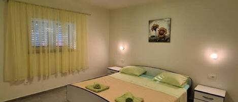 Una camera da letto con un letto, comodini, un tappeto e un quadro appeso al muro.