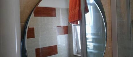 A bathroom with a tiled wall featuring a pattern of white and brown tiles.