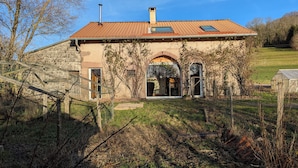 A rustic stone house with a tiled roof, a wooden door, and a small window. - La Mignonne, Vosges mountains, private spa 8 people near Gérardmer (Laveline-du-Houx)