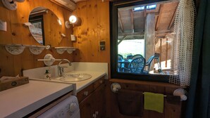 A wooden cabin bathroom with a sink, mirror, and window overlooking an outdoor area. - La Mignonne, Vosges mountains, private spa 8 people near Gérardmer (Laveline-du-Houx)