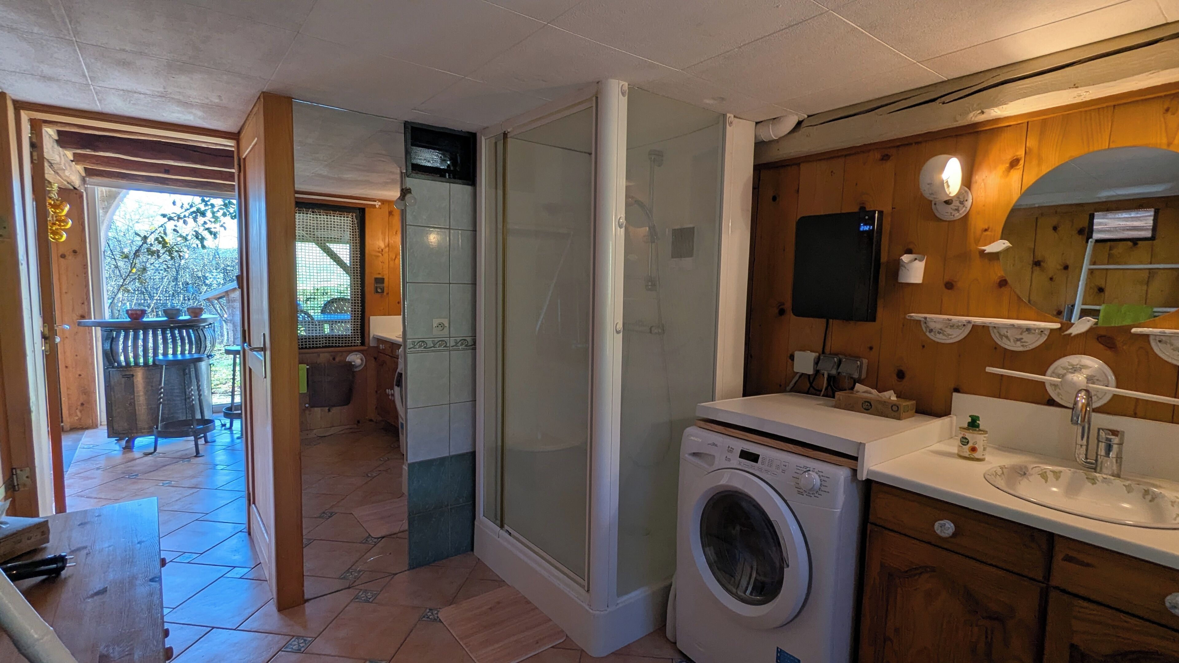 A compact kitchen with a washing machine, a sink, and a small window.