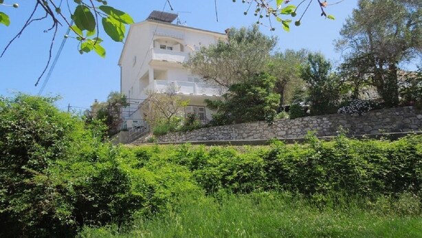 Un bâtiment à deux étages doté d’un mur en pierre et d’un balcon.