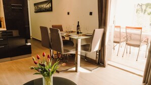 Ein Essbereich mit einem Tisch für zwei Personen, einer Vase mit Tulpen und einem Stadtbild an der Wand.