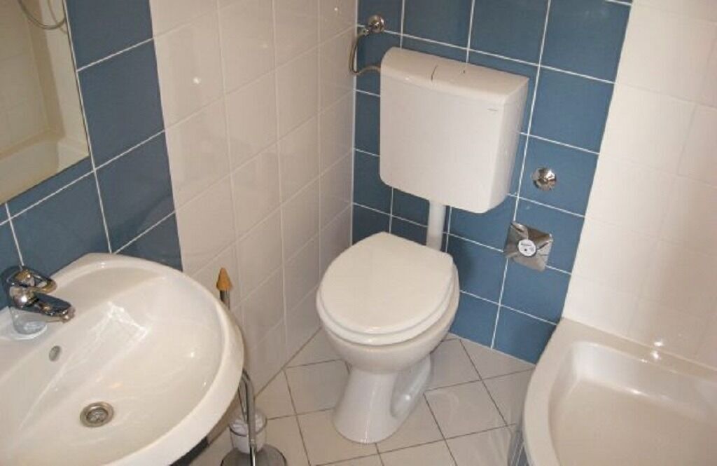 A bathroom with a white sink, a toilet, and a bathtub.