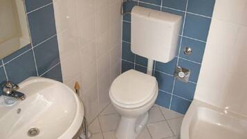 A bathroom with a white sink, a toilet, and a bathtub.