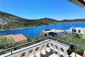 A coastal view with a clear blue sea, terraced houses, and a balcony with a railing. - Apartment Petar (Marina)
