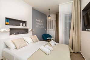 A modern hotel room with a bed, a side table, a chair, a TV, and a wall with a motivational quote. - Apartment At the sea (Slivno)