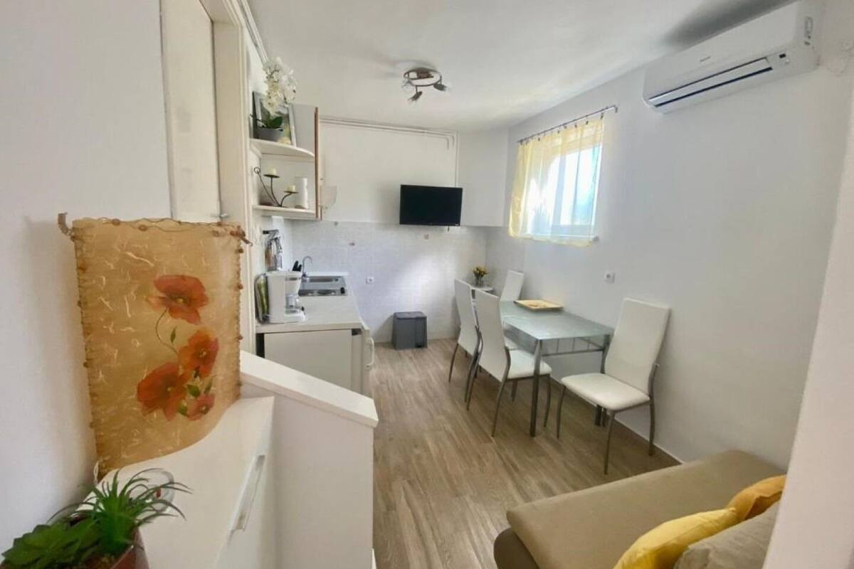 A compact living space with a kitchenette, dining area, and a small seating area.