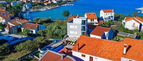 Una zona residencial costera con casas de tejados rojos y vistas al mar.