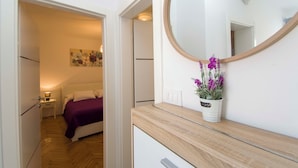 A bedroom with a bed, a nightstand, a dresser, a mirror, and a potted plant. - House Branka (Vir)