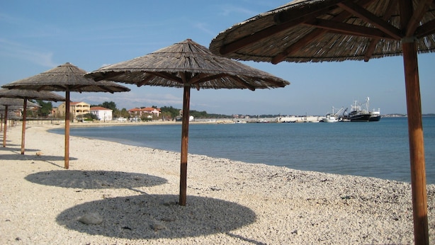 A beach with pebbles and thatched umbrellas. - House Branka (Vir)