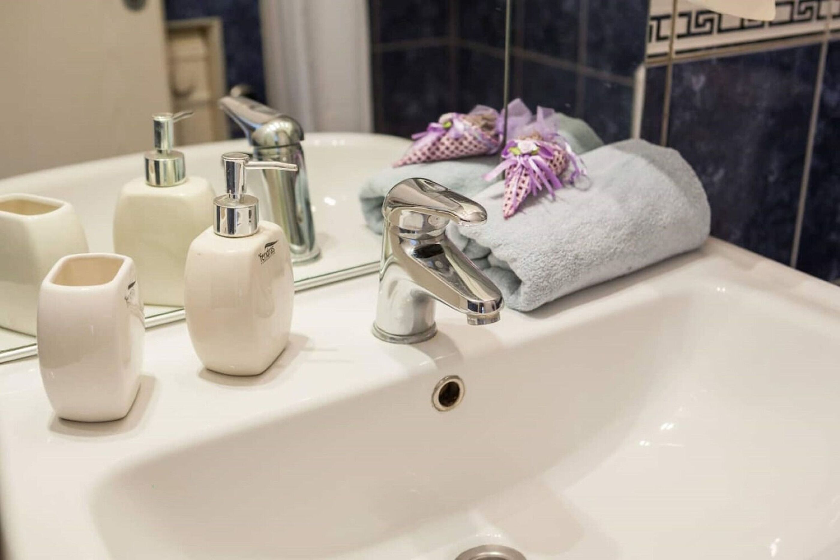 Un lavabo de salle de bain avec un miroir, un robinet et des articles de toilette.