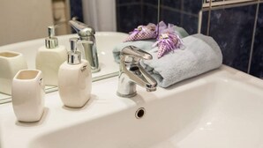 A bathroom sink with a mirror, a faucet, and toiletries. - Apartment Dragica 1 (Split)