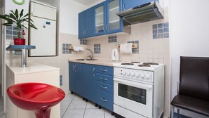A compact kitchen with blue cabinets, a white stove, and a red sink. - Apartment Dragica 1 (Split)