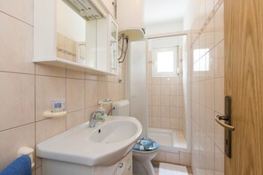 Ein Badezimmer mit Waschbecken, Toilette und Dusche.