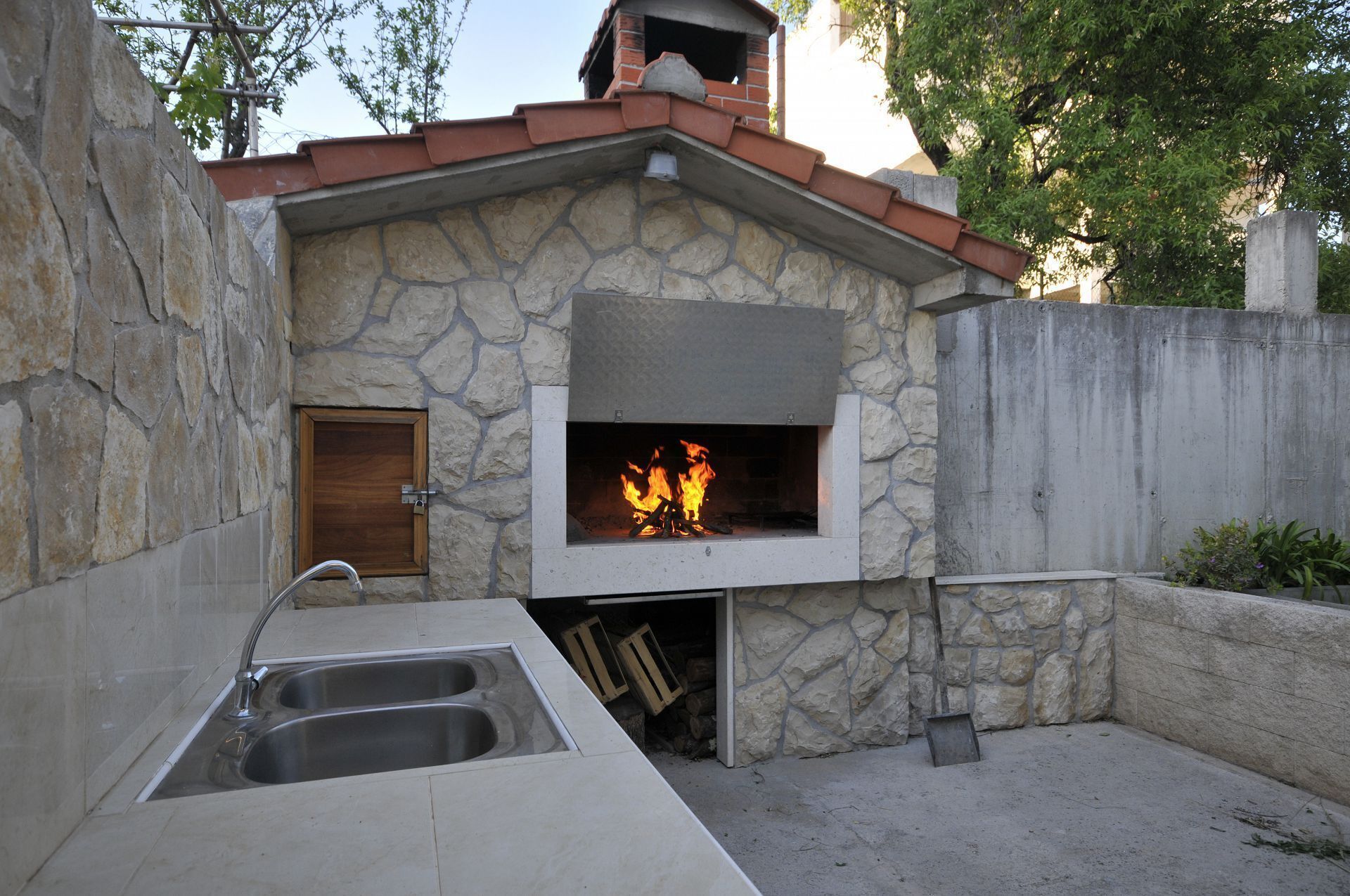A stone building with a fireplace, a sink, and a door.
