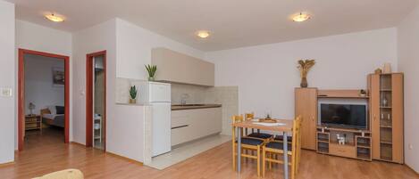 Un appartement moderne comprenant une cuisine, un coin repas et un salon.
