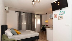 A modern hotel room with a bed, a desk, and a TV. - Apartments Edvard (Split)