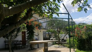 Un cortile con una panchina, un pergolato e un furgone bianco parcheggiato nelle vicinanze.