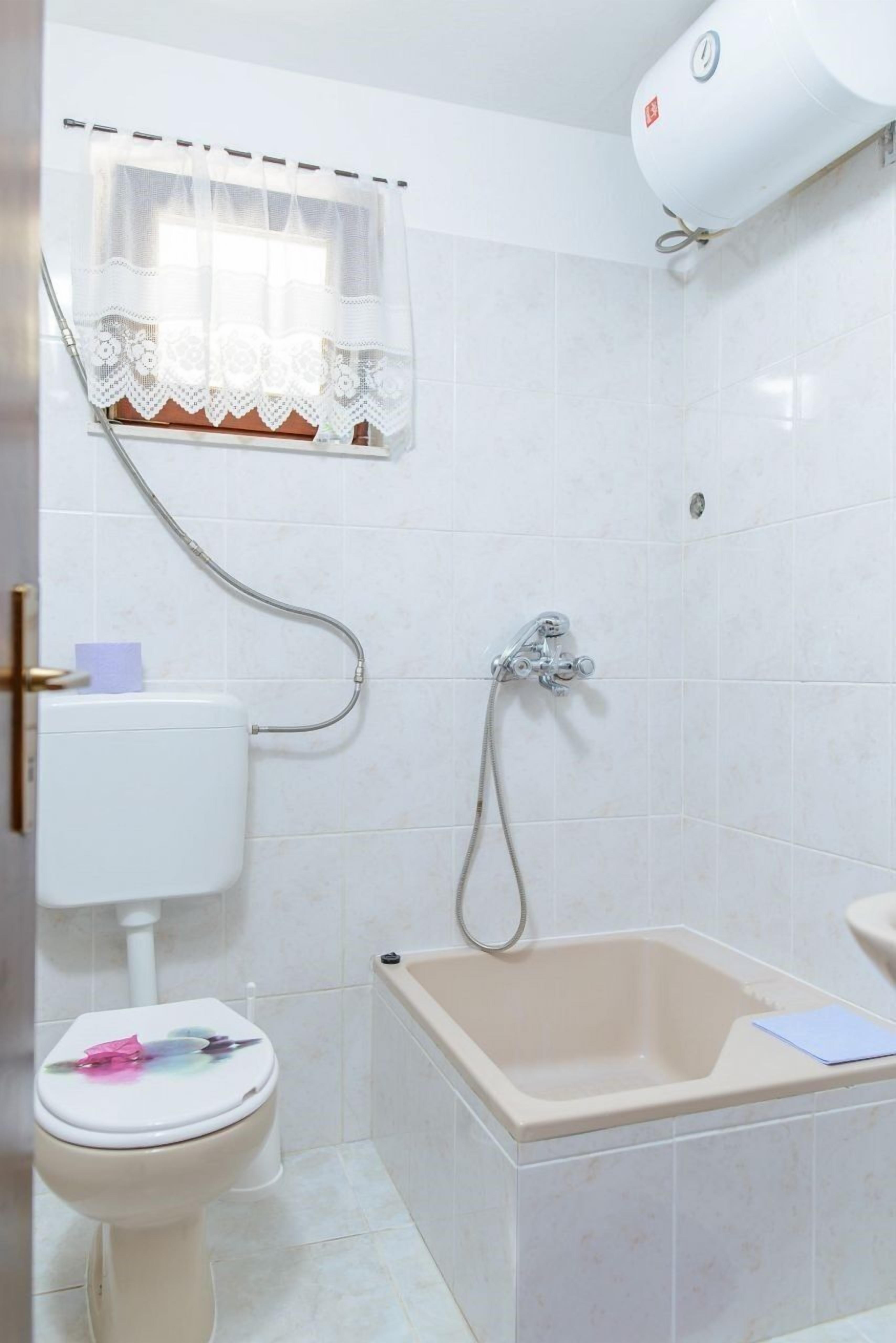 A bathroom with a toilet, a shower, and a bathtub.
