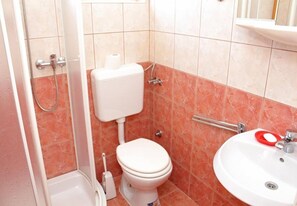 Un bagno con toilette, doccia e lavandino.