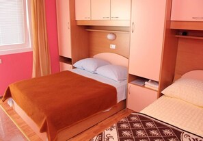 Una camera da letto compatta con un letto singolo, un comodino e un armadio a muro.