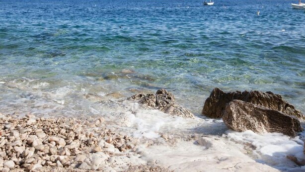 A clear beach with rocky foreground and calm sea. - Apartments Desa (Blato)