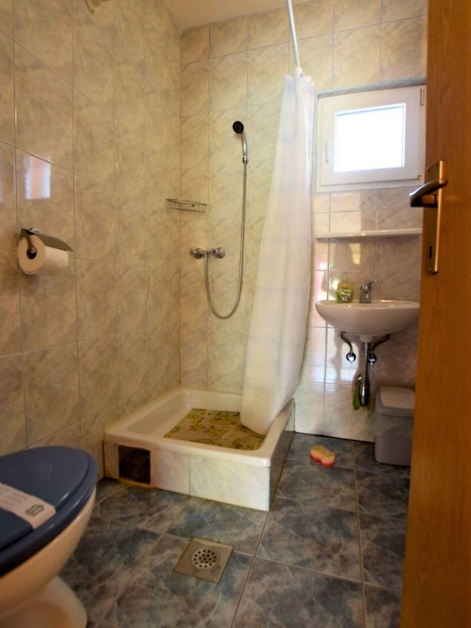 Un baño con ducha, inodoro y lavabo.