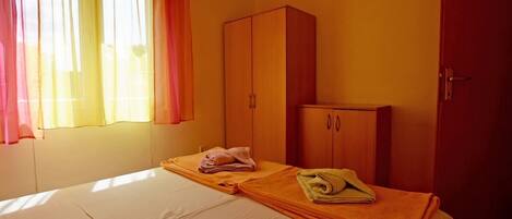 A room with a bed, a wardrobe, and a door.