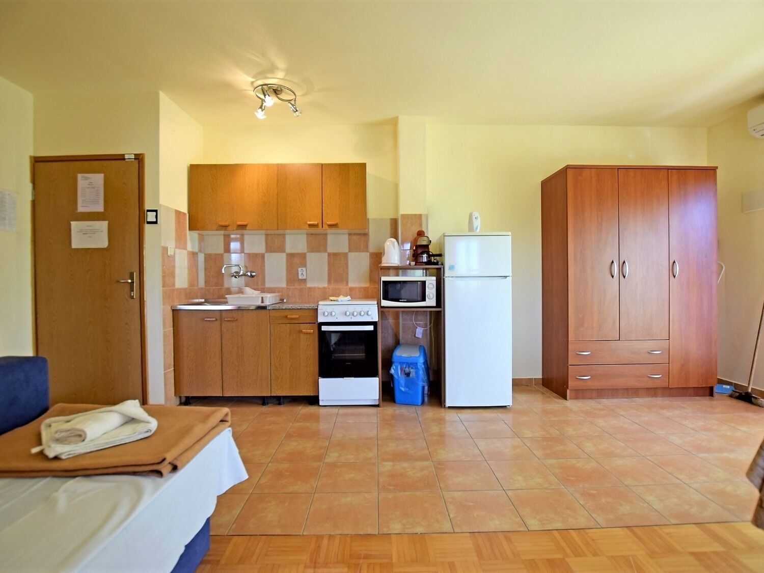 Una cocina compacta con armarios de madera, estufa, microondas y refrigerador.