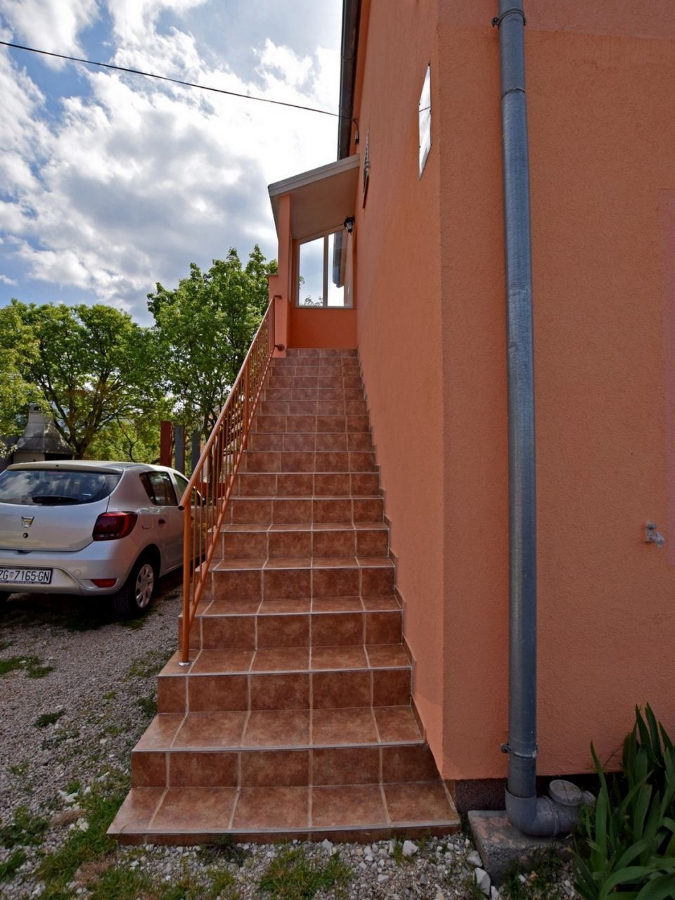Un escalier menant à un bâtiment dont la façade est recouverte de carreaux.
