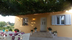 An outdoor patio with a table and chairs, a door, and potted plants. - House Andro (Bibinje)