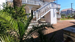 Un bâtiment à deux étages, doté d’un balcon blanc et d’un escalier menant à l’étage supérieur.