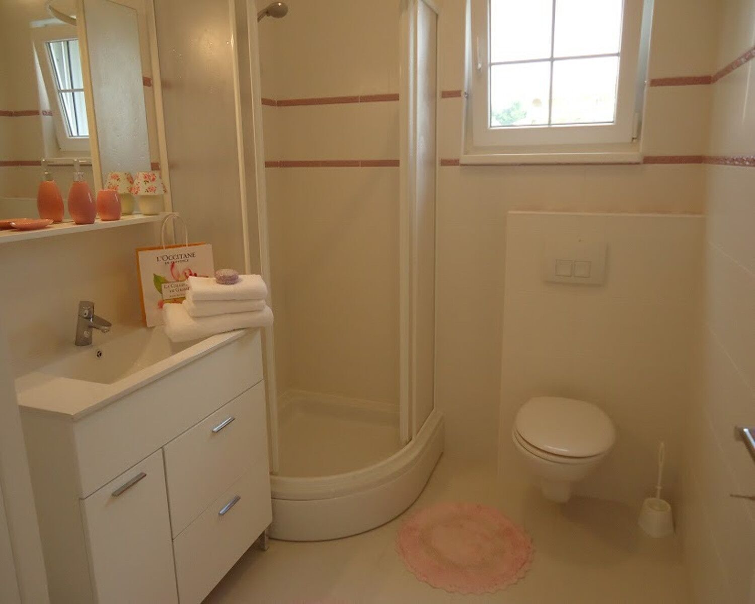 Un baño con ducha, inodoro, lavabo y espejo.