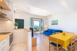 A modern apartment with a kitchen, dining area, and a living room with a sofa and a table.