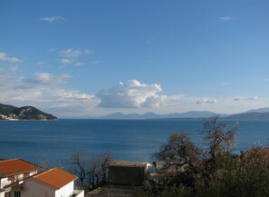 A coastal view with a clear sky, calm sea, and distant mountains. - Apartment Bianca (Podgora)