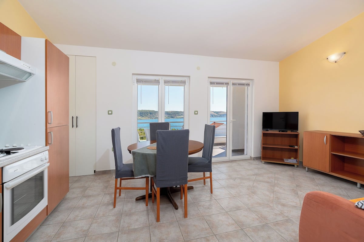 Un espacio habitable compacto con cocina, comedor y televisor.