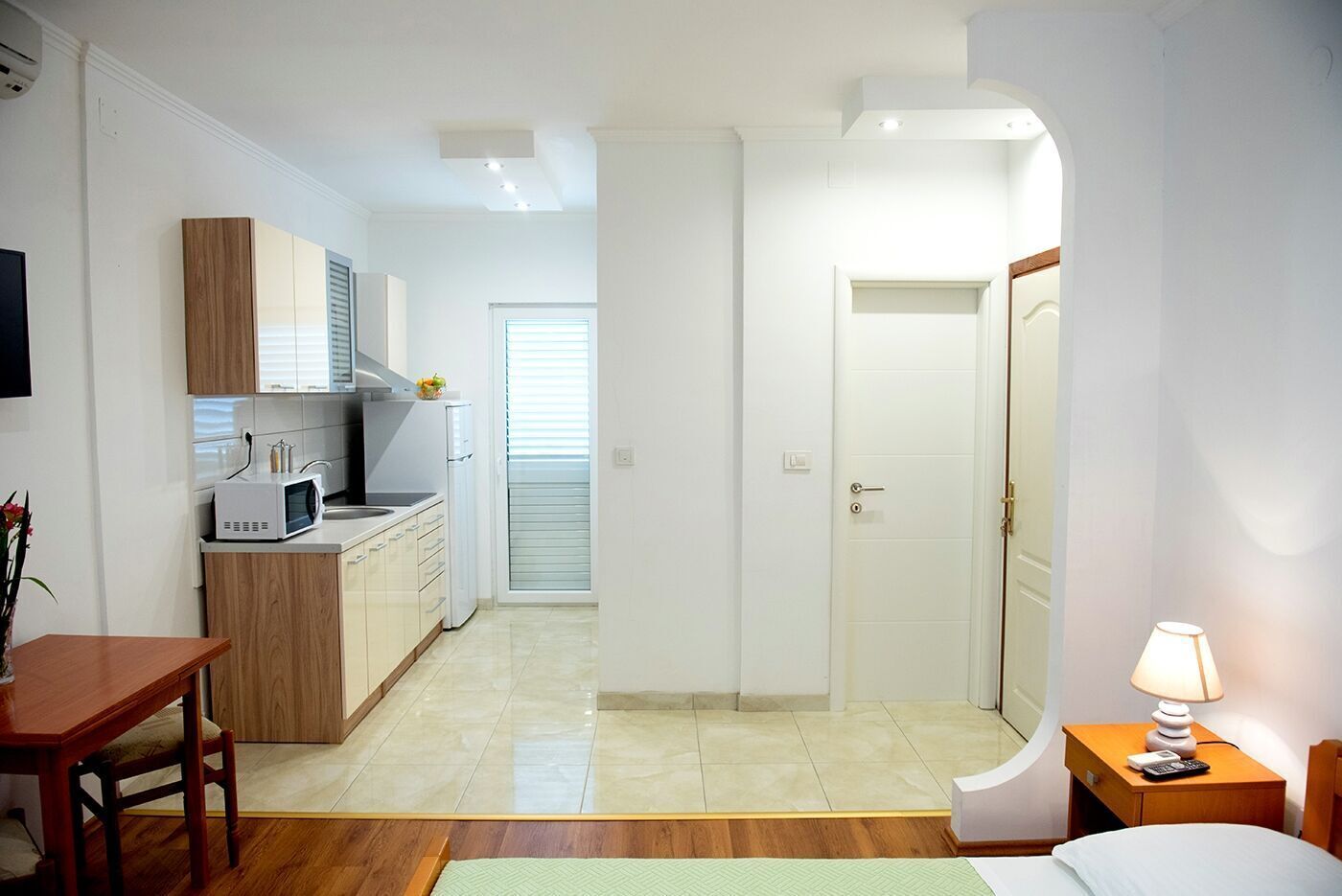 Ein kompaktes Hotelzimmer mit Küchenzeile, Essbereich und einer kleinen Sitzecke.