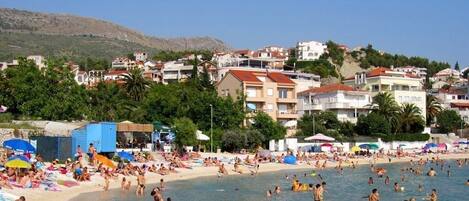 Une ville côtière dotée d’une plage, de bâtiments et bordée de collines.